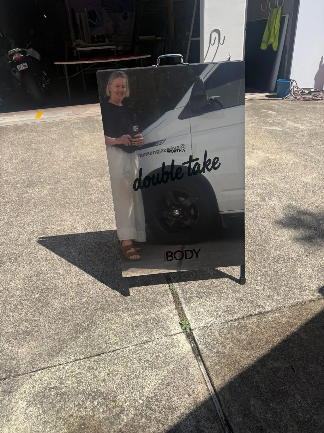 Mirror A-frame sign reading worth a double take with Cotton On Body branding