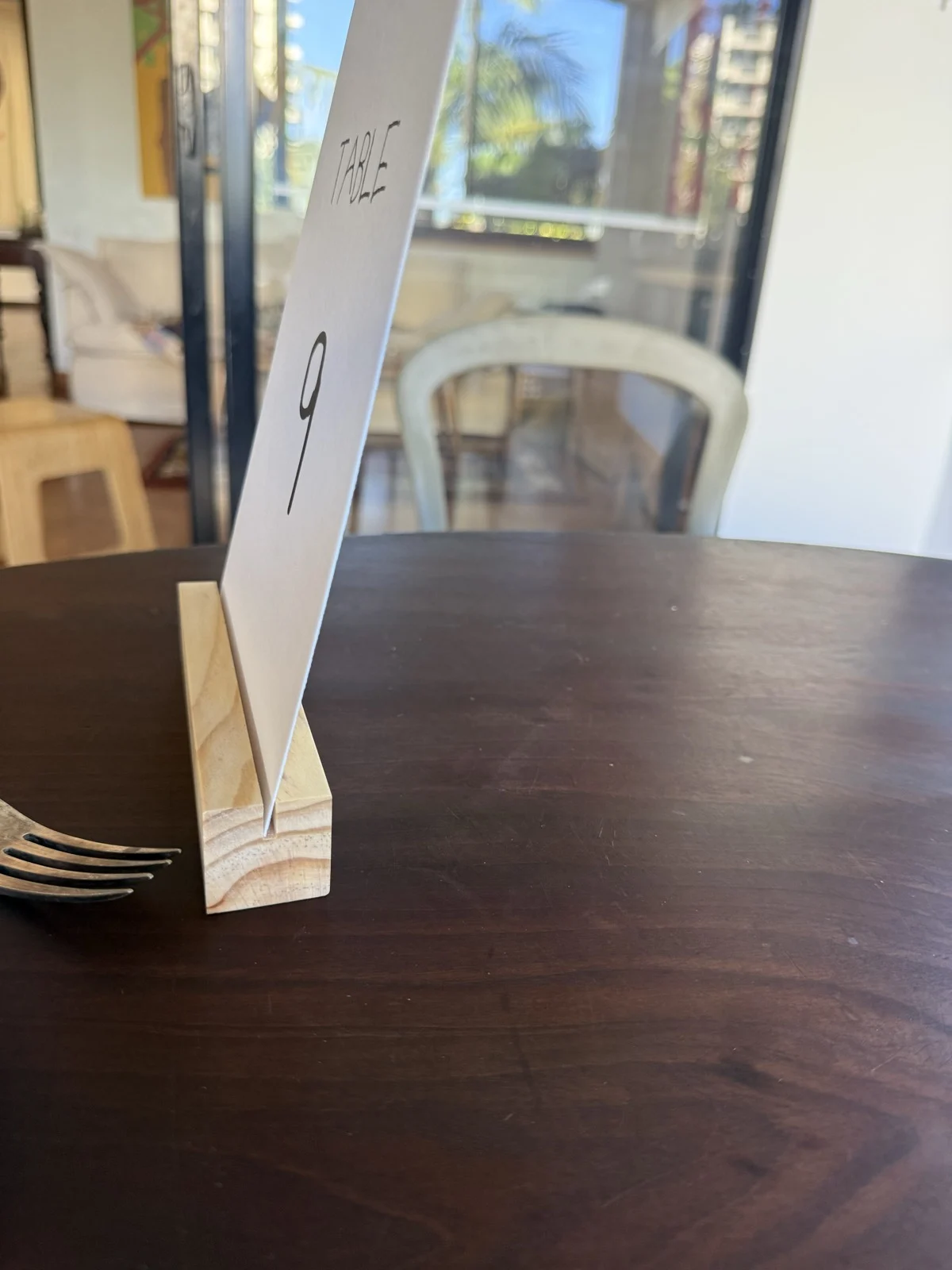 Side view of a table number card held upright in a pale timber stand